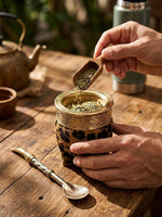 Load image into Gallery viewer, Hands filling the animal-print imperial mate gourd with loose yerba mate