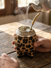 Hot water being poured into the animal-print torpedo mate gourd